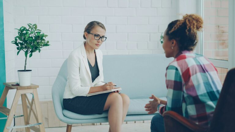 Therapist talking with a client in a bright therapy office